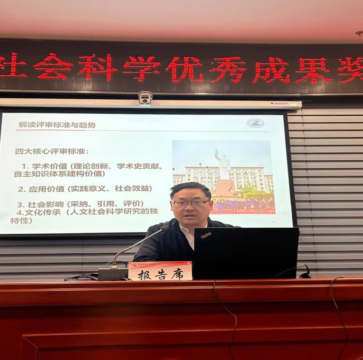 A person sitting at a podium with a screen behind him AI-generated content may be incorrect.